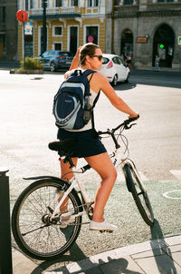 Woman riding bicycle on street in city