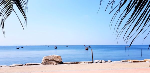 Scenic view of beach against clear blue sky