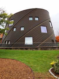 Lawn by building against sky