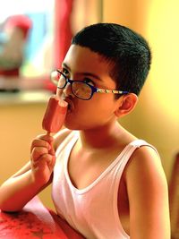 Boy looking up while eating ice cream at home