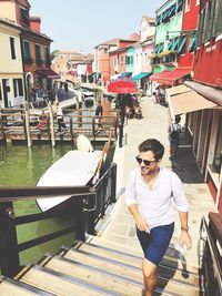 Full length of young man in sunglasses at canal