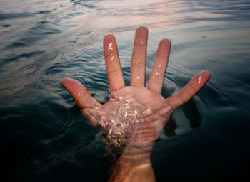 Cropped hand in lake