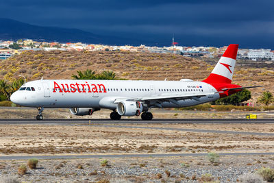 Airplane on airport runway against sky