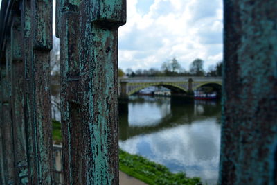 Bridge over lake seen through weathered railing