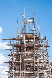 Low angle view of cranes against blue sky