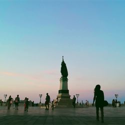 Group of people walking in front of historical building