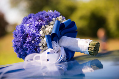 Close-up of purple bouquet on car bonnet