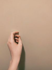 Close-up of woman hand against wall