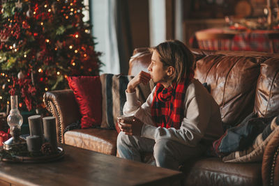 Portrait of candid authentic smiling boy teenager having fun emotion at wooden lodge xmas decorated