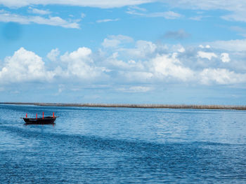 Boat sailing in sea against sky