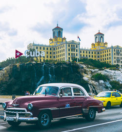 Cars on road against buildings in city