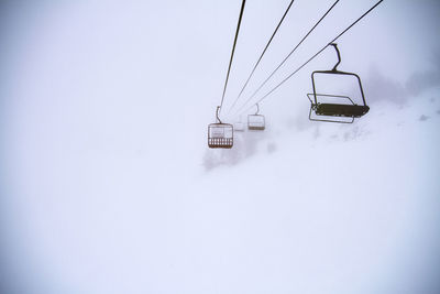 Ski lifts on snow covered landscape