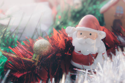 Close-up of santa claus figurine by christmas decorations on table