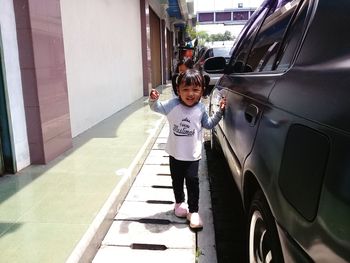 Girl standing beside car