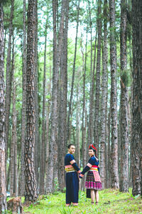 People on road amidst trees in forest