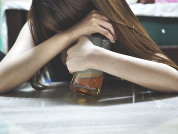 Close-up of depressed woman having alcohol at home