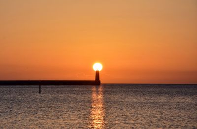 Scenic view of sea against orange sky