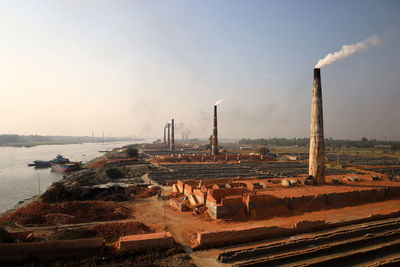 Panoramic view of factory against sky during sunset