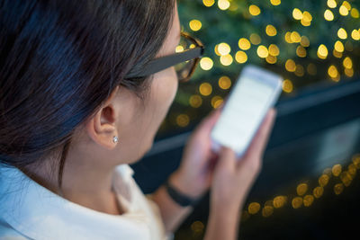 Rear view of girl using mobile phone