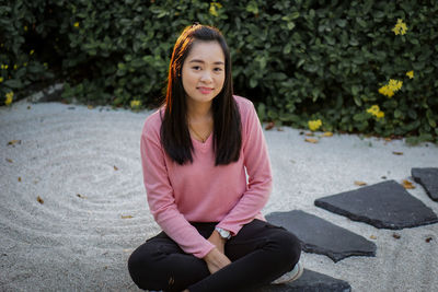 Portrait of young woman sitting on field