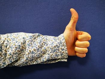 Cropped hand showing thumbs up sign