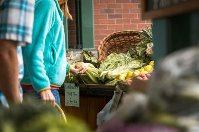 Woman in farmer's market looking at greens