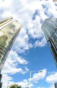 Low angle view of modern building against cloudy sky