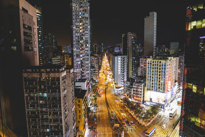 High angle view of illuminated street amidst buildings in city at night