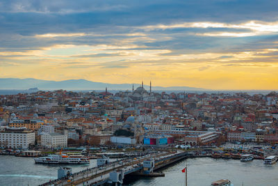 High angle view of river by buildings against sky during sunset