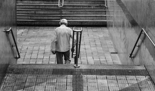 Rear view of man walking on footpath