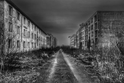 Road amidst buildings against sky