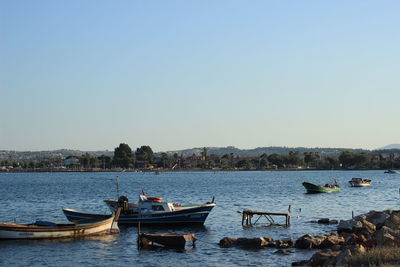 Boats moored in lake against clear sky