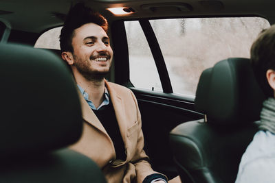 Close-up of happy businessman traveling in car