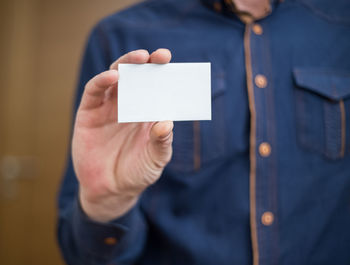 Close-up of man holding paper with text