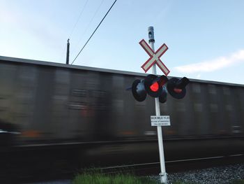 Information sign on railroad track against sky