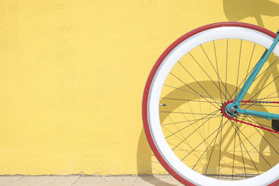 Close-up of bicycle against yellow wall