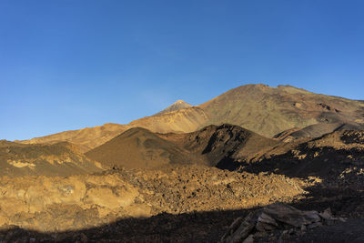 Scenic view of mountains against clear blue sky