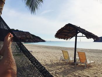 Low section of person on beach against sky