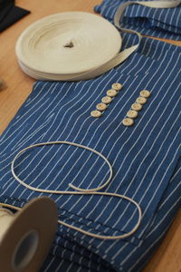 High angle view of blue cloth with sewing items on table