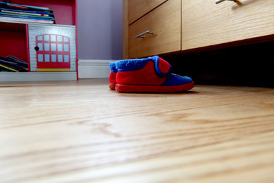 Close-up of shoes on hardwood floor at home