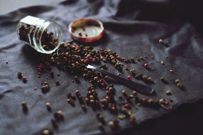 Close-up of black peppercorns spilling on fabric