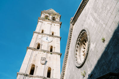 Low angle view of clock tower against clear blue sky