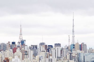 Modern buildings in city against cloudy sky