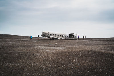 People on airport runway against sky