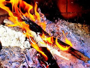 Close-up of bonfire on wooden log at night