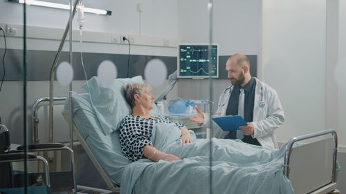 Midsection of doctor examining patient in clinic