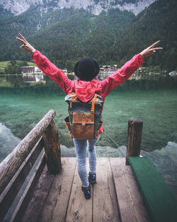 Full length rear view of man standing by lake