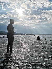 Silhouette man standing on beach against sky