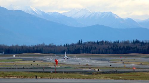 Scenic view of field and mountains against sky