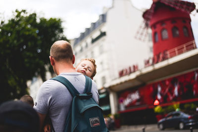 Rear view of father with son standing in city